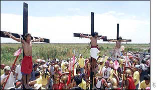 From left, Rolly Turla, Ruben Enaje and Emerito Baking re-enact the crucifixion of Jesus Christ by having themselves nailed on the cross
